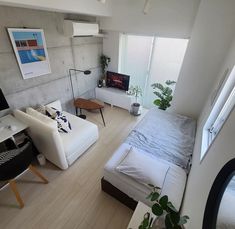 a bedroom with a bed, desk and television in it's center area is seen from above