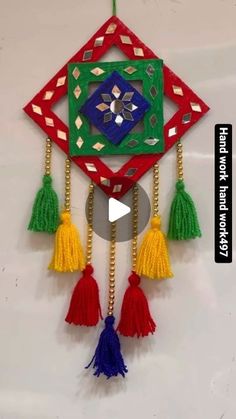 an ornament with tassels hanging from it's side on a wall