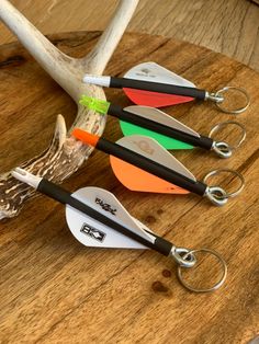 four different colored deer antlers are sitting on a wooden table next to each other