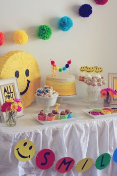 a table topped with lots of cakes and desserts covered in pom - poms