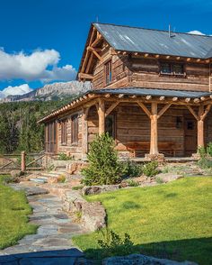 an old log cabin with stone steps leading up to it