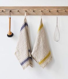 two kitchen towels hanging on a wooden rack