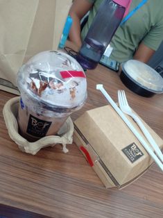 an ice cream sundae is sitting on a table next to a box and two forks