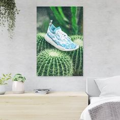 a white and blue sneaker sitting on top of a green plant next to a bed