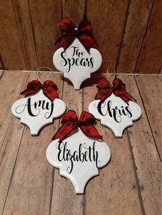 three white ceramic ornaments with red bows and the words mr and mrs are hanging on a wooden wall