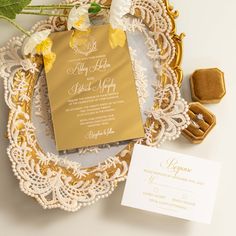 the wedding stationery is laid out on a lace doily