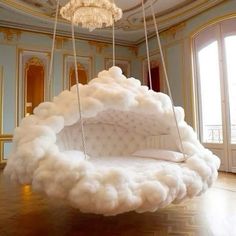 a white couch suspended from a chandelier in a room