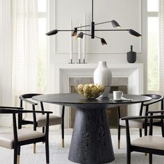 a dining room table with chairs around it and a vase sitting on top of the table