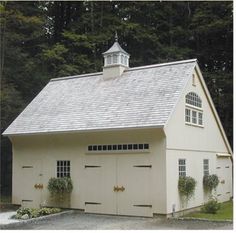 a white garage with two windows and a steeple