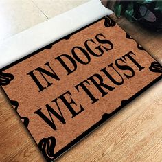 a door mat with the words in dogs we trust on it next to a potted plant