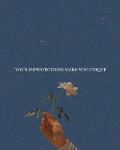 a person holding a flower in their hand with the words your imperfections make you unique