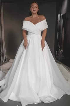 a woman in a white wedding dress posing for the camera