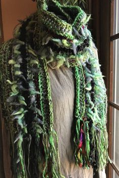 a mannequin wearing a green scarf with fringes on it's sides