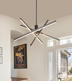 a modern style ceiling light in a living room with stairs and artwork on the wall