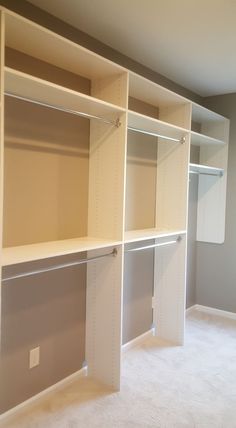 an empty room with white shelving in the middle and carpeting on the floor