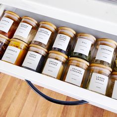 an open refrigerator filled with lots of different types of food in jars on top of a wooden floor