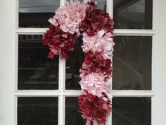 a candy cane rag wreath hanging on a window sill with the words christmas project