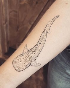 a banana tattoo on the arm with dots all over it's body and tail