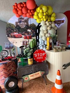 there is a stop sign and some balloons on the wall in this party decoration area