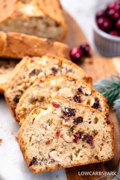 slices of cranberry walnut bread on a cutting board with fresh cranberries in the background