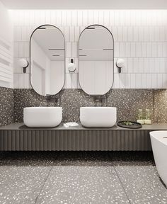 a bathroom with two sinks and mirrors on the wall next to a bathtub in front of a tiled wall