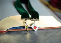 a pair of gold and green medals on top of a book with a ribbon around it