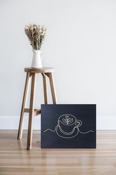 there is a vase with flowers on the table next to a sign that says coffee