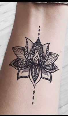 a black and white photo of a woman's leg with a flower tattoo on it