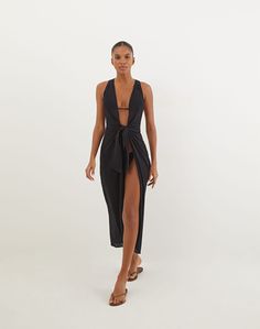 A piece that exudes sophistication and effortless style, the Mita Long Cover Up is a standout in the ViX + Bianca Brandolini Capsule Collection. This semi-sheer cover-up features a captivating narrow back cut detail, adding a touch of sensuality. The front is equally stunning with a knot closure that flatters the waist and holds its shape perfectly. This versatile piece is designed to elevate your swimwear for those must-cover-up moments, making it a luxurious addition to any wardrobe. Pair this Sleek Swimwear For Summer Evenings, Sleek Swimwear For Evening In Summer, Sleek Evening Swimwear For Summer, Chic Black Party Cover-up, Chic Fitted Party Cover-up, Elegant Sleeveless Vacation Cover-up, Elegant Sleeveless Spring Cover-up, Elegant Sleeveless Beach Cover-up, Elegant Fitted Beach Cover-up