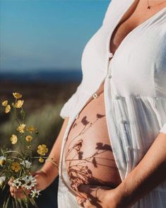 a pregnant woman holding flowers in her belly