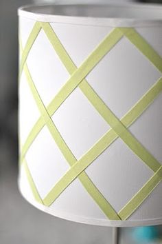 a white lamp with yellow strips on it and a green stripe around the bottom of the lamp shade