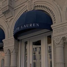 the front entrance to a building with blue awnings and white trim on it