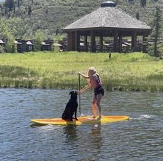 a woman on a paddle board with her dog