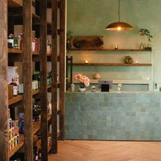 a room that has shelves with bottles on it and some flowers in the vases