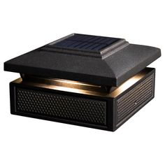 a solar powered light that is on top of a black box with gold trimmings