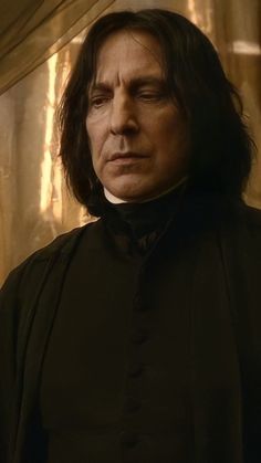 a man with long hair wearing a black outfit