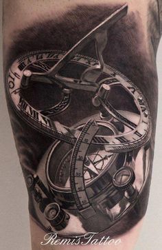 a man's arm with a clock and compass tattoo on the left side of his leg