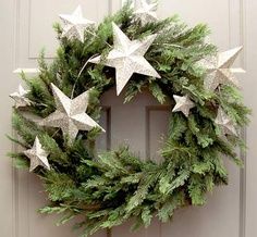 a wreath with white stars hanging on a door