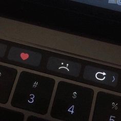 a laptop keyboard with an emoticive smiley face on it's display screen