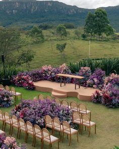 an outdoor ceremony set up with chairs and flowers in the foreground, surrounded by mountains