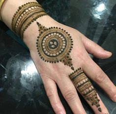 a woman's hand with henna tattoos on it