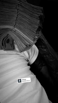 a stack of money sitting on top of a person's back covered in paper