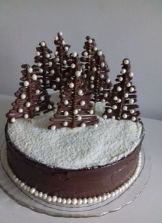 a cake decorated with chocolate trees and white frosting