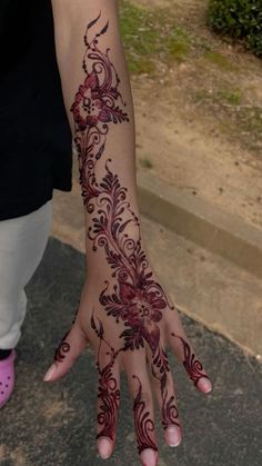 a woman's hand with henna tattoos on it