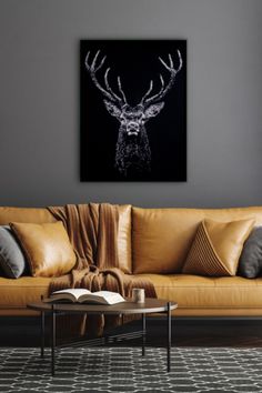 a living room with a couch, coffee table and deer head on it's wall