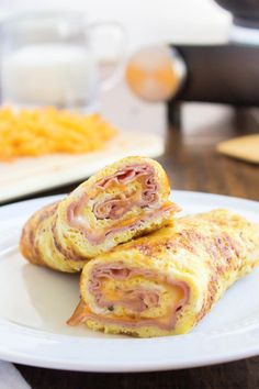 two ham and cheese pastries on a white plate with macaroni and cheese in the background