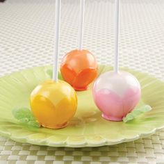 there are three pictures of candy cake pops on the plate and one is being dipped with icing