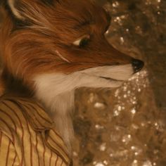 a close up of a stuffed fox wearing a shirt