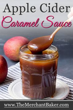 an apple cider caramel sauce in a glass jar on a plate with apples