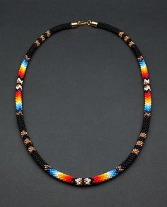 Add a touch of cultural flair with this ethnic beaded choker necklace. Inspired by Native American traditions, the intricate beadwork and unique design make it a standout piece of jewelry. Southwestern Black Beaded Necklaces For Festivals, Southwestern Black Beaded Necklace For Festivals, Handmade Southwestern Black Beads, Artisan Black Beaded Necklace Handwoven, Handwoven Black Beaded Necklace As Gift, Southwestern Black Necklace With Colorful Beads, Artisan Black Handwoven Beaded Necklace, Artisan Handwoven Black Beaded Necklace, Black Bohemian Handwoven Beads